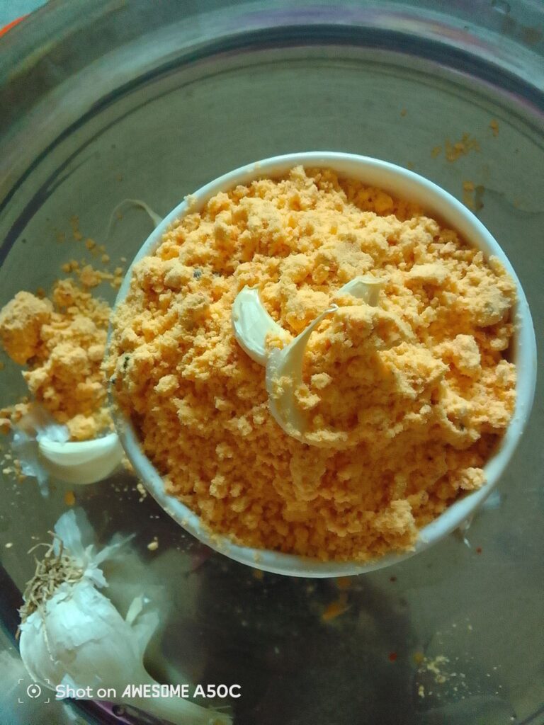 “Homemade Andhra Pappula Podi served in a bowl with hot rice and ghee, traditional South Indian chutney powder made with roasted chana dal, garlic, and red chilies.”